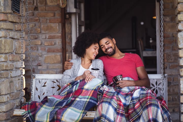 african-american couple sitting outside with a blanket