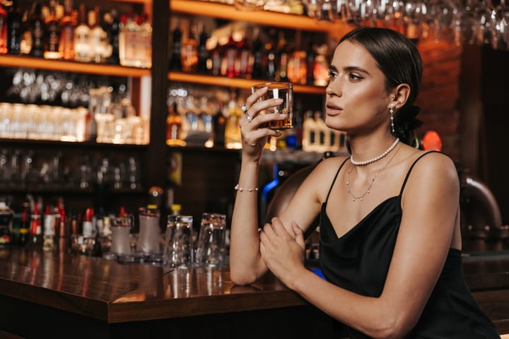 young woman drinking alone at bar
