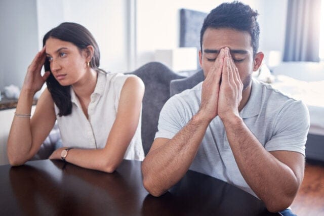 upset couple sitting at table