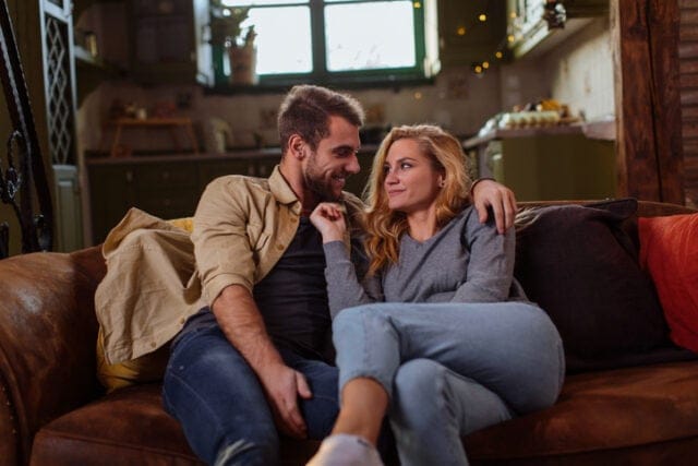 romantic couple cuddling on couch