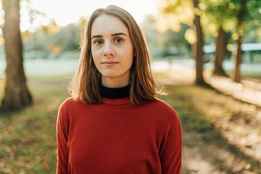 serious young woman in autumn park