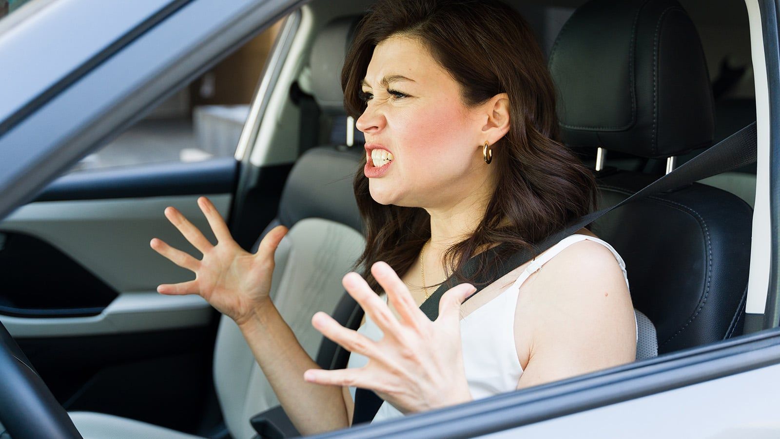 Woman angry behind wheel of car
