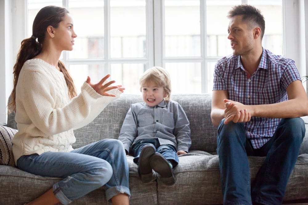 Man and wife arguing in front of child.