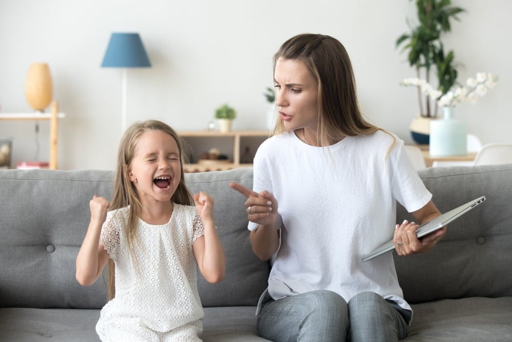 A mother scolding her child and telling her not to cry.