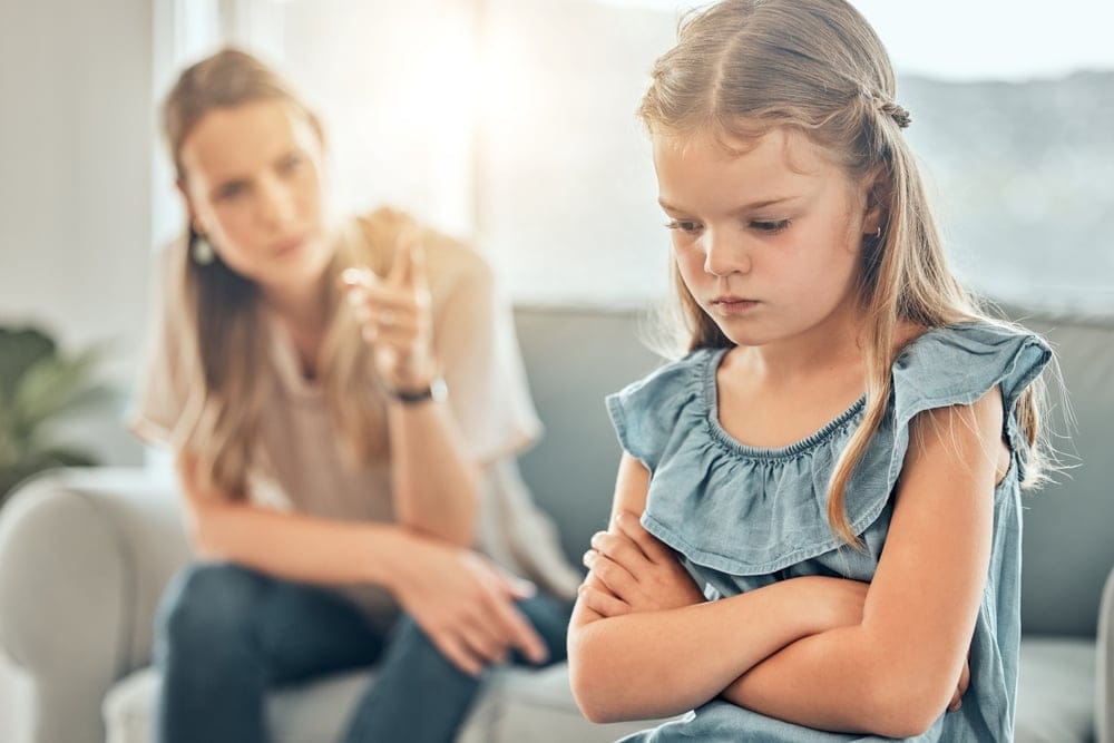 An angry young mother scolds her little girl child