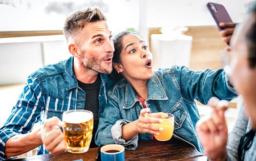 smiling couple taking selfie at brewery