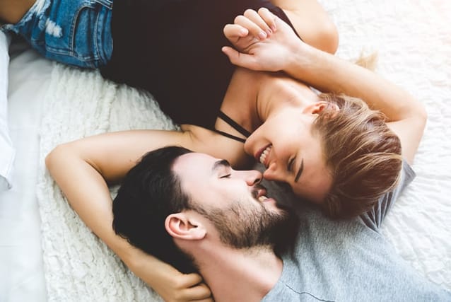 smiling couple in bed
