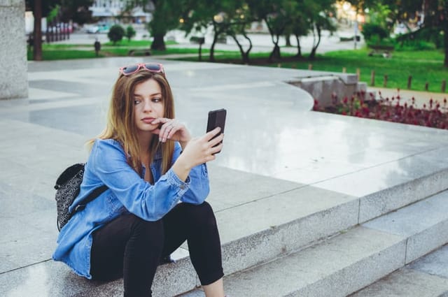 upset woman texting outdoors