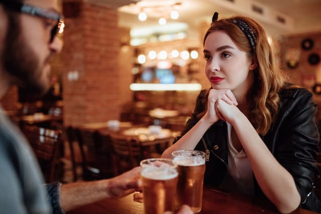 couple feeling each other out at pub