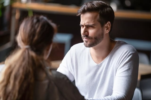 skeptical man looking at woman