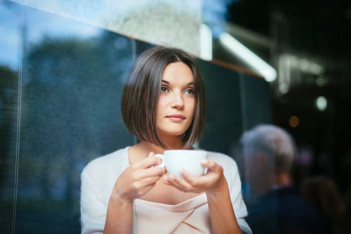 Beautiful woman with coffee cup restaurant window