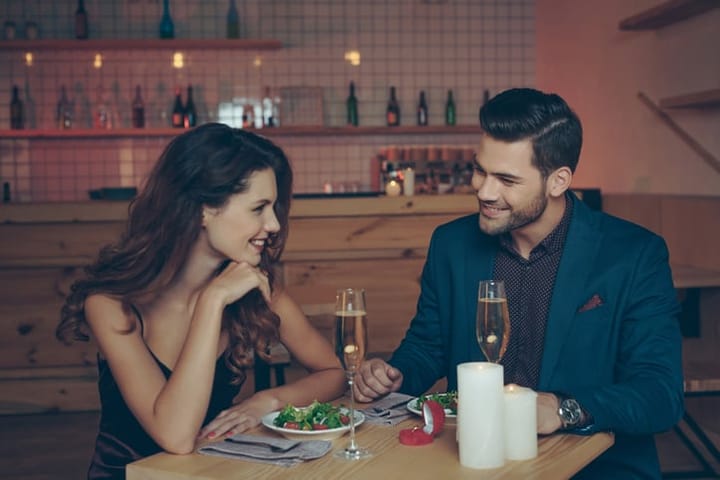 young couple in love having romantic dinner together in restaurant