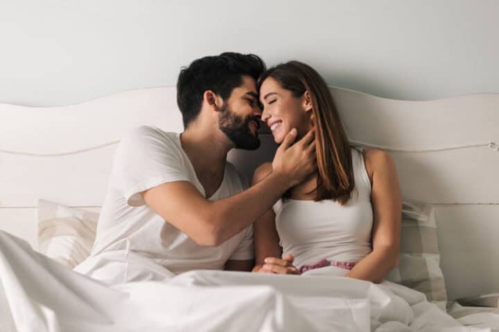 couple kissing in bed